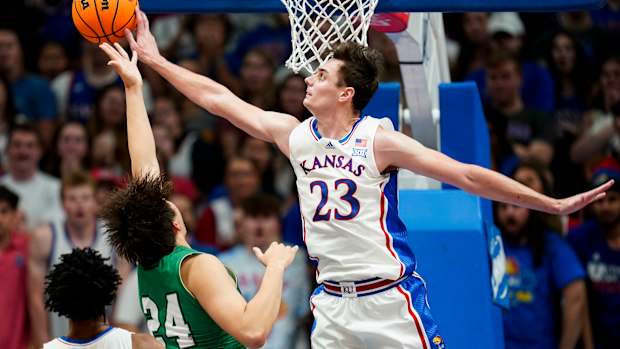 Nov 10, 2023; Lawrence, Kansas, USA; Kansas Jayhawks forward Parker Braun (23) blocks the shot of Manhattan Jaspers forward Xinyi Li (24) during the first half at Allen Fieldhouse. Mandatory Credit: Jay Biggerstaff-USA TODAY Sports  